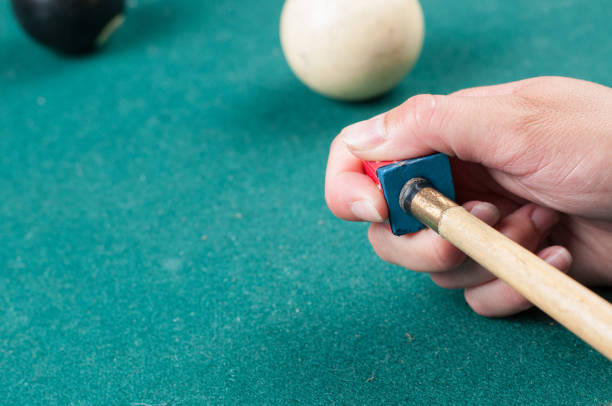 istock Cue stick with chalk block on green billiard table.Chalk block on pool table. 1164218188