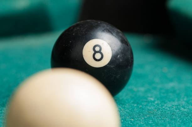 istock Old billiard ball 8 on a green table. billiard balls isolated on a green background. 1164219048