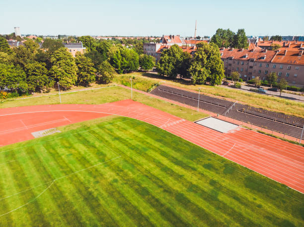 istock stadium with green grass and red running line 1164219052