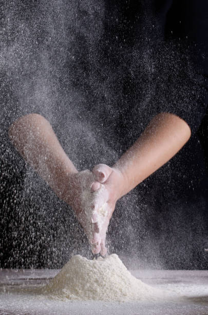 istock The cooking process, hands on a black background, flour. Confectioner 1164220136