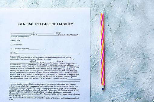 Filling General Release of Liability form paper on bright background