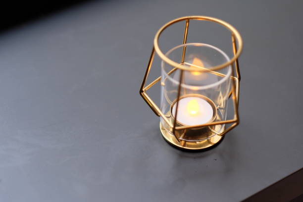 istock close up one modern golden candle light on grey background. 1164223085