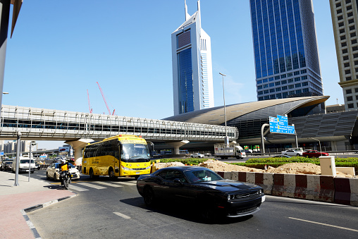 Dubai, UAE - November 19, 2017: The Dubai cars traffic is near Dubai Metro station and Emirates Towers.