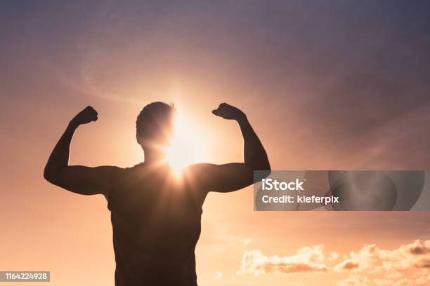 Strong Man At Sunset Stock Photo - Download Image Now - Strength, Muscular Build, Exercising