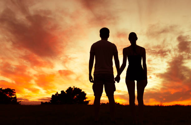 istock Romantic couple holding hands at sunset. 1164225887