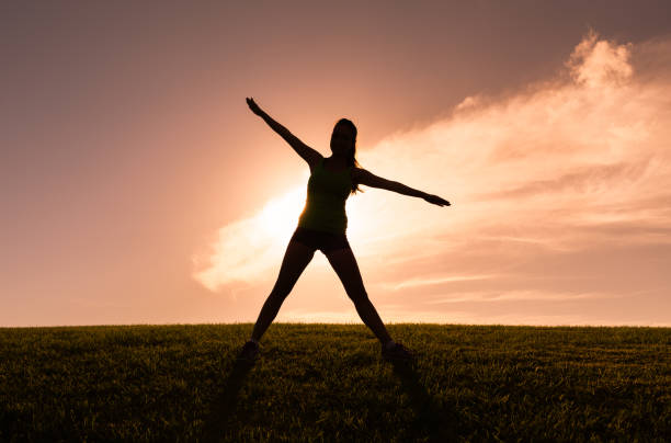 istock Woman stretching at sunset 1164225942