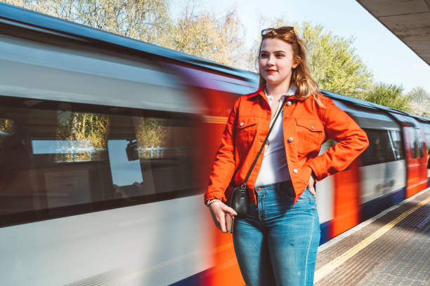 istock Woman student in red jacket waiting for a train 1164226995