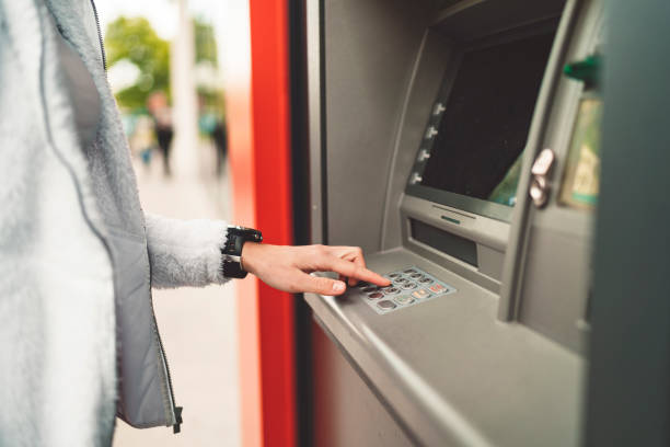 istock Woman typing her pin code on the ATM to make a deposit 1164227063