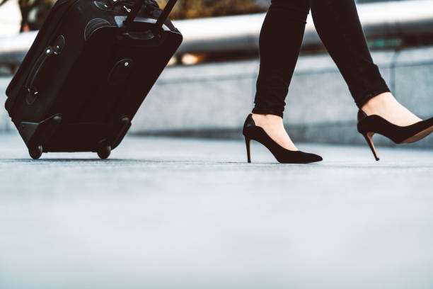 istock Woman legs in black heels and a suitcase 1164227690