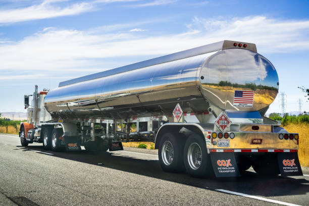 Tanker truck driving on the freeway June 28, 2019 Tracy / CA / USA - Tanker truck driving on the freeway, the road and sky reflected in its shiny cistern; oil tanker stock pictures, royalty-free photos & images