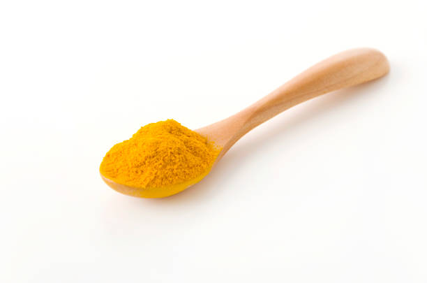 cúrcuma (curcuma) polvo en cuchara de madera sobre fondo blanco - spice condiment spoon wooden spoon fotografías e imágenes de stock