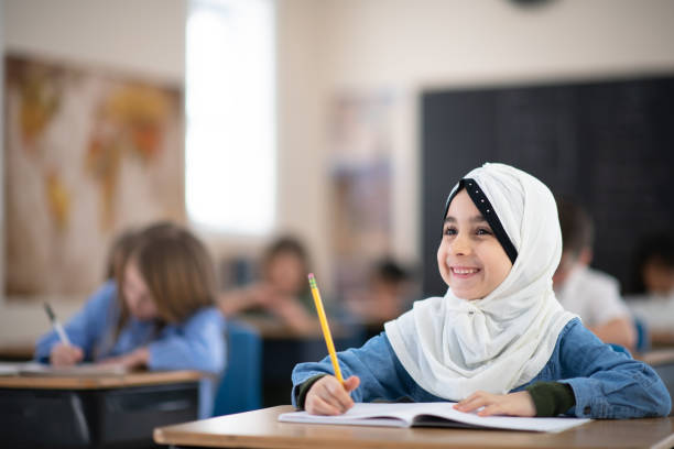 istock Muslim Girl Writing in her Notebook in Class 1164233529