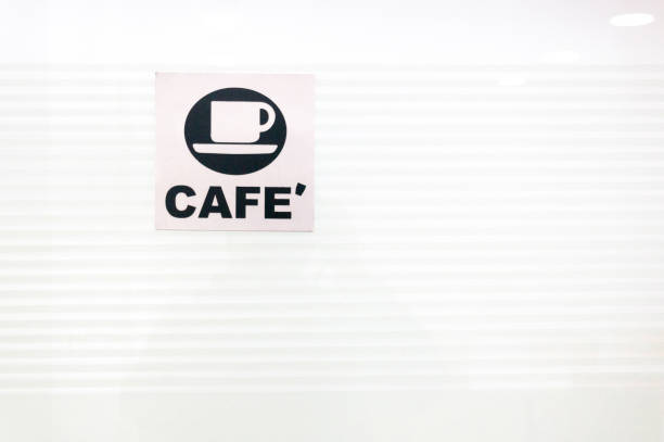 Cafe sign in black and white with a coffee cup on a white glass background. Shows the way to a cafe in an office, airport, train station and other public spaces