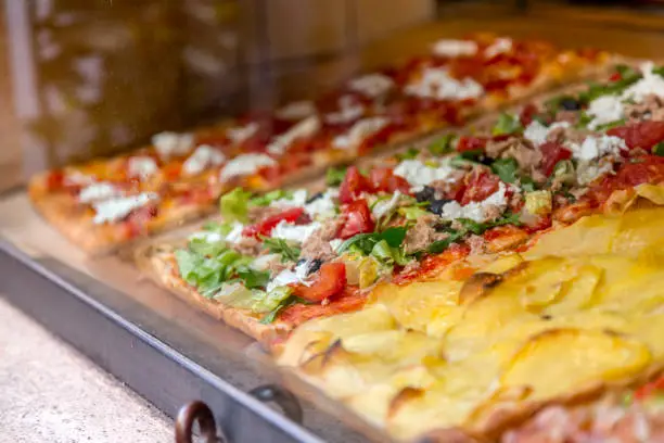 Photo of Italian pizza in a restaurant display window in Rome