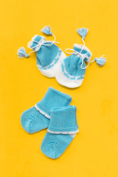 istock Baby gloves and socks on yellow background. 1164243764