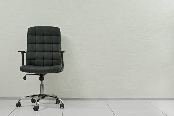 soft black office leather armchair against empty wall in office interior with copy space soft black office leather armchair against empty wall in office interior with copy space office chair stock pictures, royalty-free photos & images