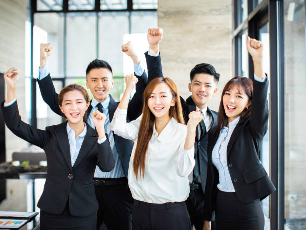 istock confident asian business team hands up and celebrating 1164246589