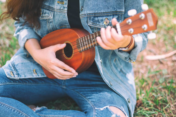 istock A woman sitting and playing ukulele 1164246787