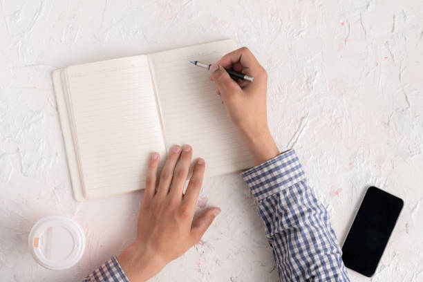 istock top view of hands with pen taking notes at his workplace, copy space 1164248311
