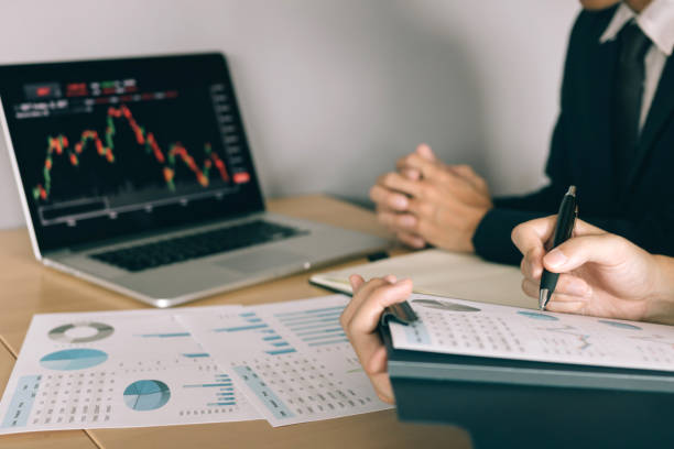 istock Two investors are working together with analyzing the stock data graphs in the paper and viewing the data on the laptop screen. 1164248565