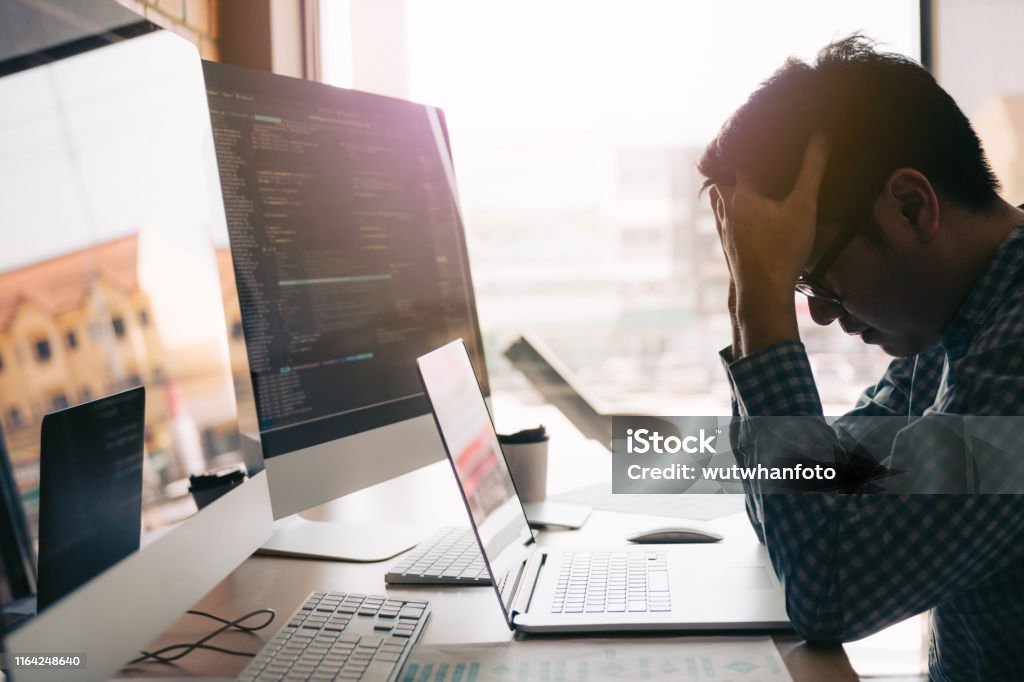 Softwareentwickler haben Kopfschmerzen mit der Codeanalyse im Büro. - Lizenzfrei Frustration Stock-Foto Softwareentwickler haben Kopfschmerzen mit der Codeanalyse im Büro. - Lizenzfrei Frustration Stock-Foto