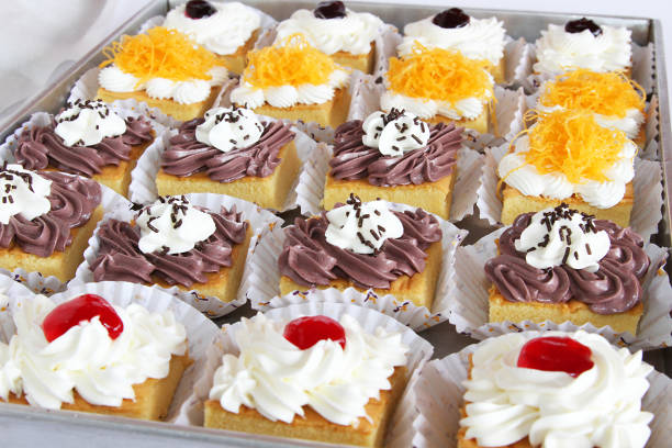 Vanilla cupcakes with blue and purple cream, chocolate and popcorn in delivery box,