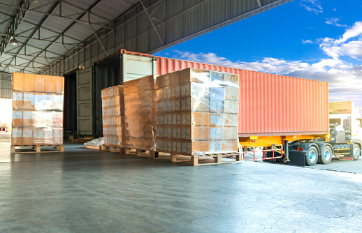 Freight transportation by trucks, trucks trailer docking loading cargo at warehouse