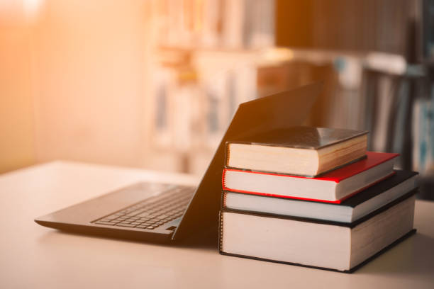 bookshelves and laptops are placed on the library desk.e-learning class and e-book digital technology - law student imagens e fotografias de stock