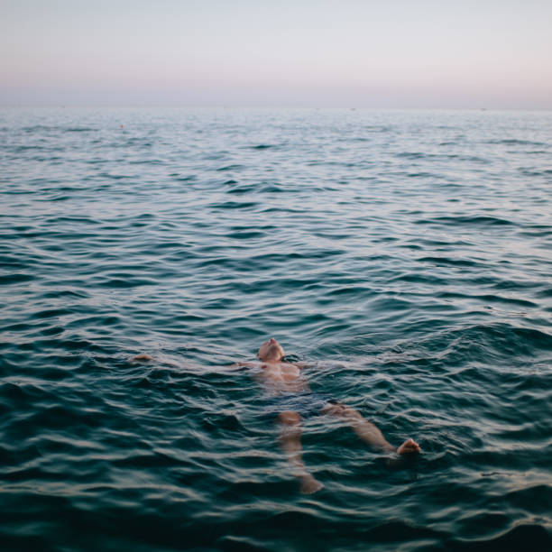 istock Man floating in blue sea 1164261835