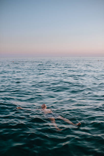 istock Man floating in blue sea 1164261842