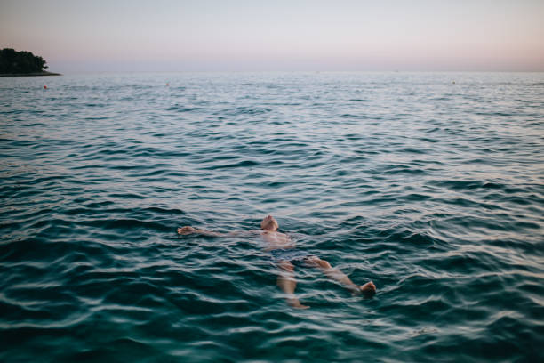 istock Man floating in blue sea 1164261843