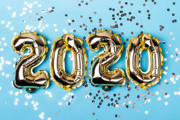 Numbers 2020 made from foil balloons on blue sparkles background. Christmas concept