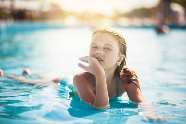 Summer is my season. Little girl lying in the pool.