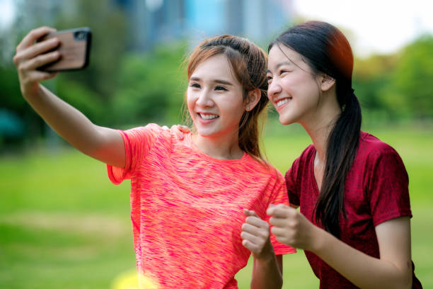 asian girl sunning and selfie togather in the park, this image can use for exercise - togather imagens e fotografias de stock