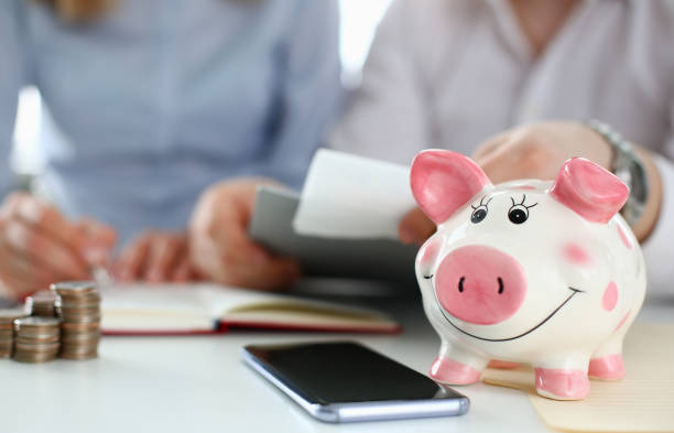 istock Piggy bank on table aganist home background 1164273155