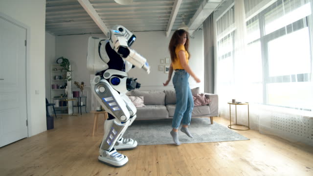 Human-like robot and a woman are dancing and jumping