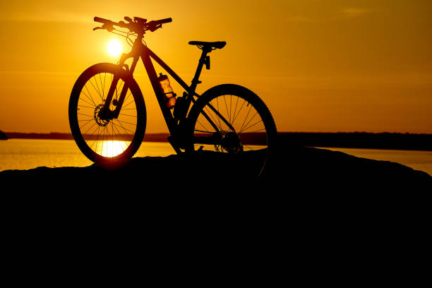 istock silhouette bike on sunrise. 1164277640