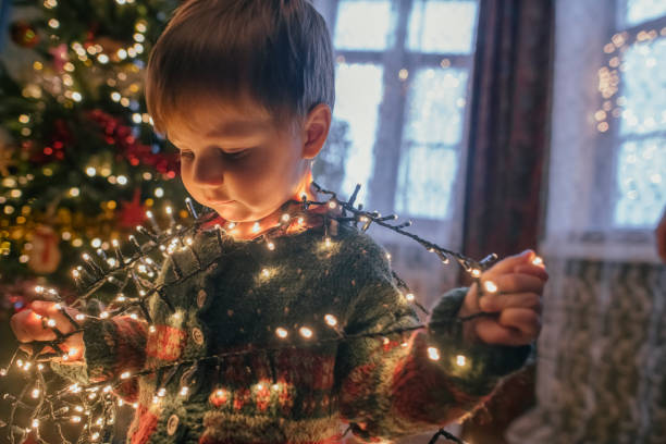 istock Little boy playing with Christmas lights at home 1164289241