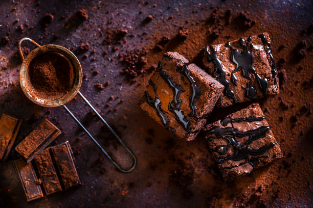 schokoladen-brownies auf dunkelbraunem tisch - brownie baked bakery brown stock-fotos und bilder