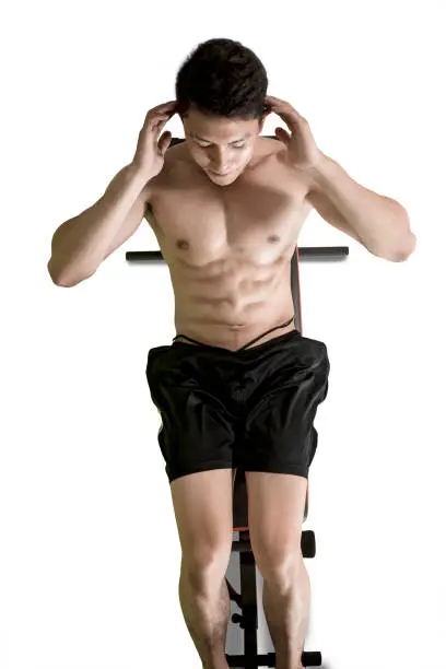 Top view of Asian man doing abdominal exercises in the studio, isolated on white background