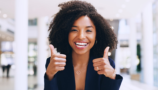 Cropped portrait of an attractive young businesswoman standing with a thumbs up gesture while in the office during the day