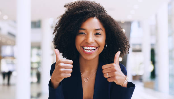 We're going to do great together! Cropped portrait of an attractive young businesswoman standing with a thumbs up gesture while in the office during the day thumbs up stock pictures, royalty-free photos & images