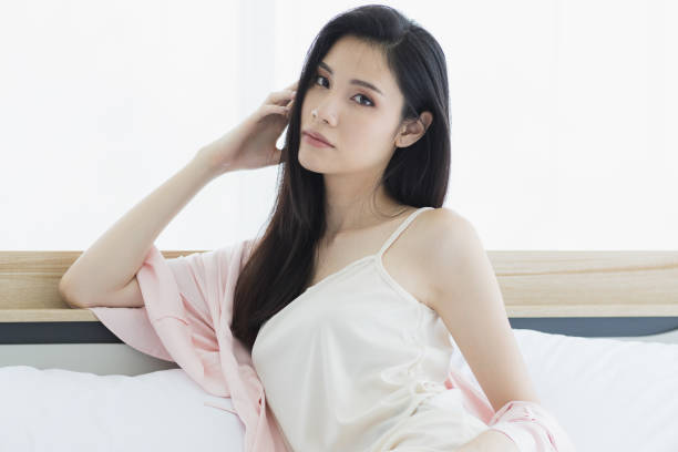 istock Asian woman model sitting and posing on bed. 1164295436