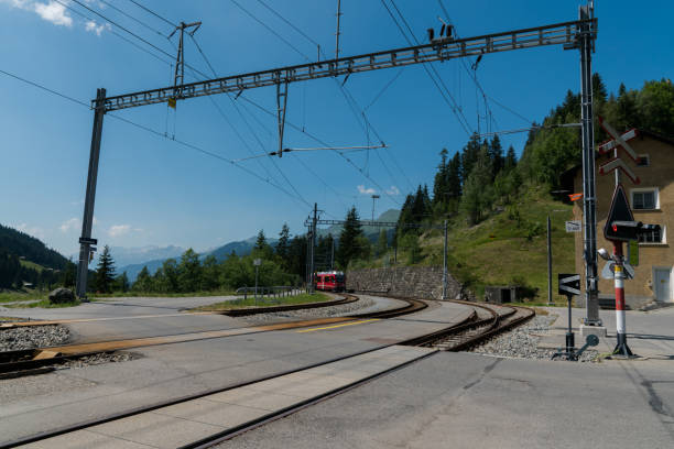 赤い狭いゲージ列車がスイスアルプスの遠隔駅に到着 - rhätische bahn ストックフォトと画像