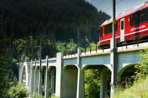 o trem estreito do calibre cruza um viaduto longo através de uma ravina profunda nos alpes suíços - rhätische bahn - fotografias e filmes do acervo