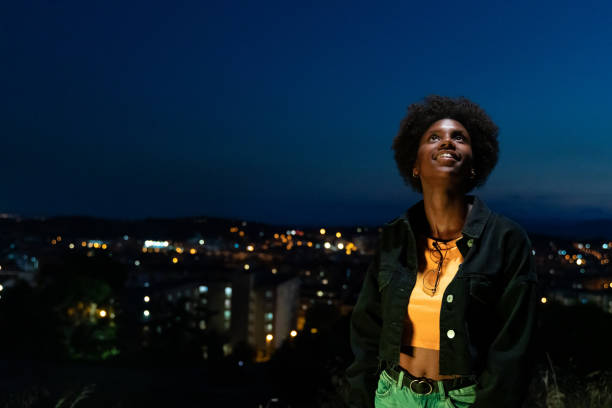 istock Young woman looking up with hope at twilight 1164299809