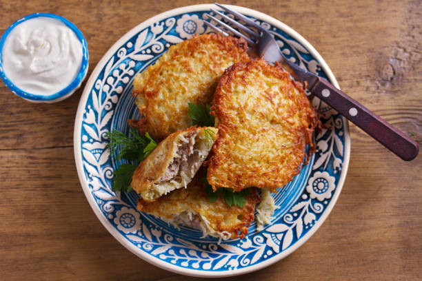 kartoffelpfannkuchen gefüllt mit fleisch. gemüsefritten gefüllt mit fleisch. latkes auf blauem teller - hash brown stock-fotos und bilder