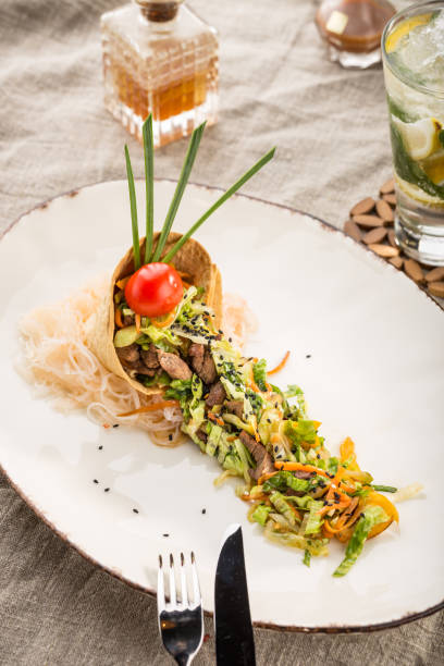 istock salad with beef, sesame seeds and vegetables in tortilla on white plate 1164304580
