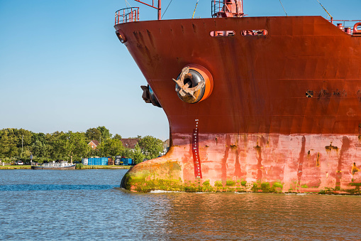 Bow of a red cargo ship in the harbor