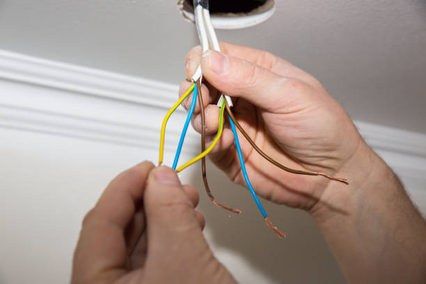 istock Man is holding adhesive tape in his hands.  Electrical insulator for light bulb. Maintenance repair works in the flat. Restoration indoors. 1164308534